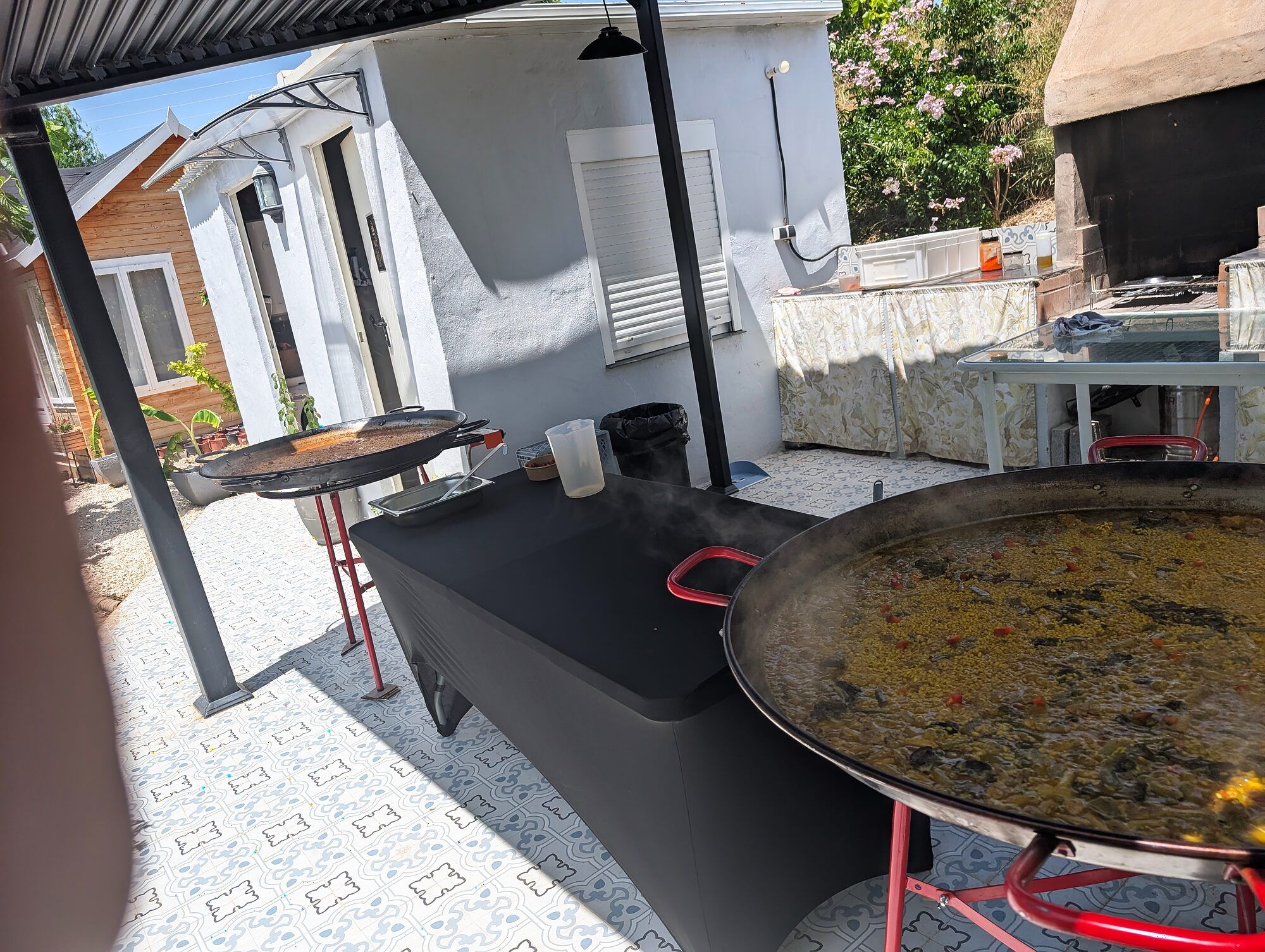Paellera y mesa de apoyo en el jardín · Estación de arroces en una boda íntima
