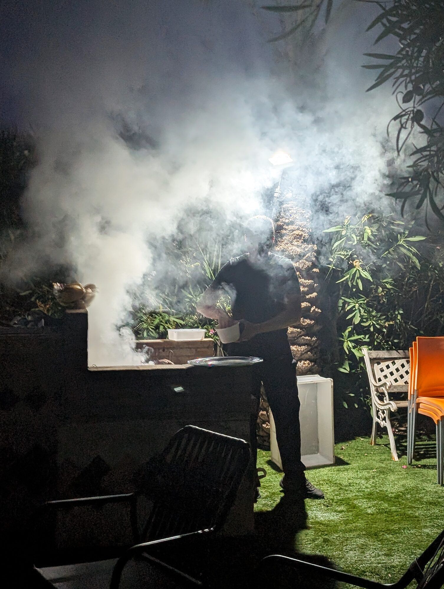El chef entre el humo de la barbacoa por la noche · Barbacoa con chef privado