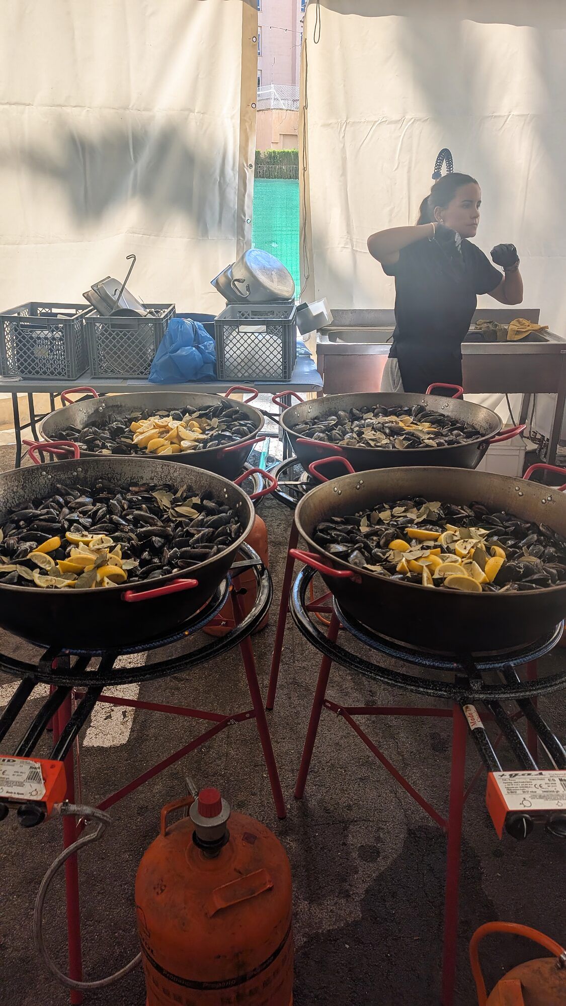 Paelleras de mejillones en la cocina de la carpa · Fiestas patronales bajo carpa