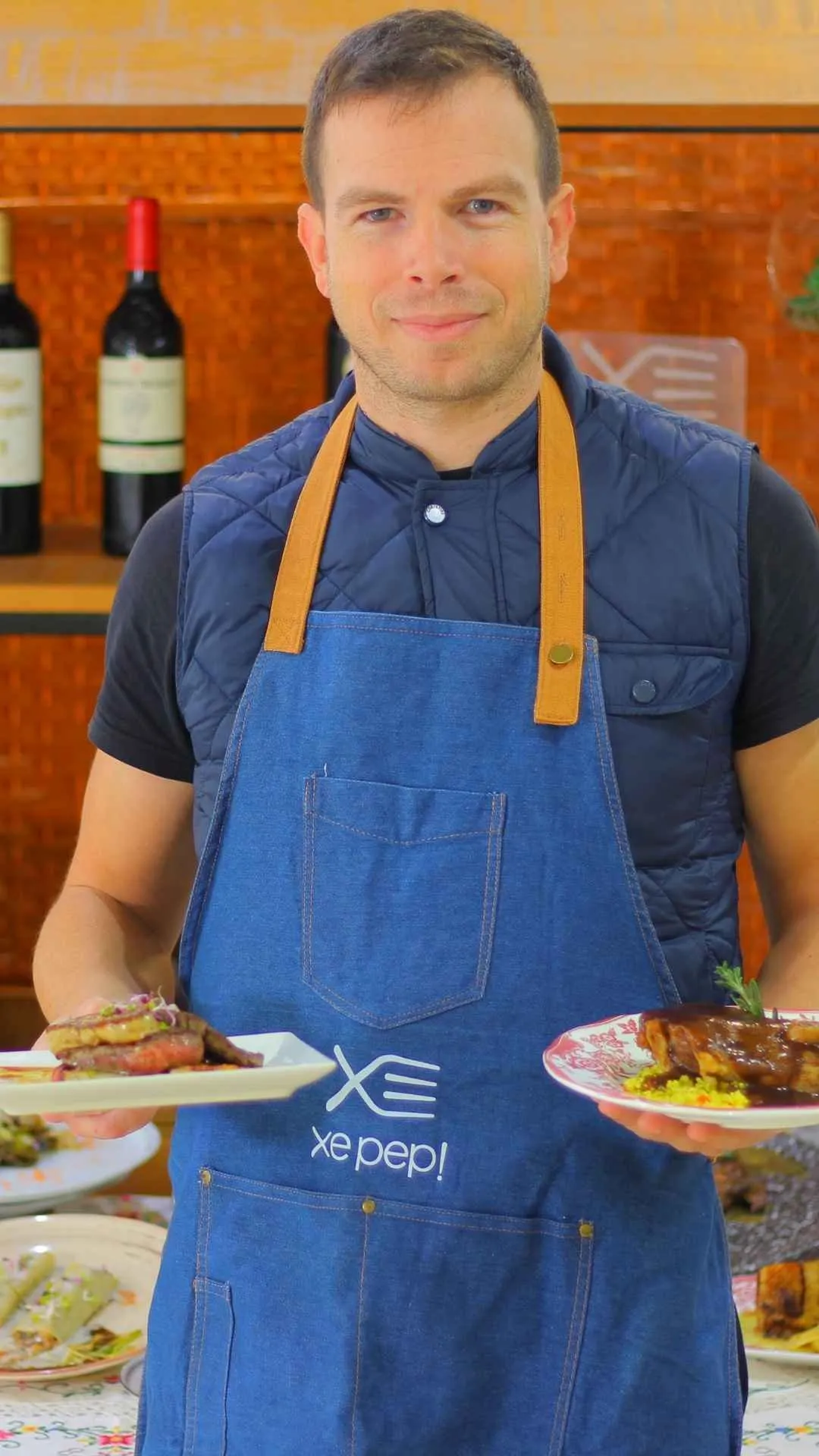 José Galipienso, cocinero de Xepep, con el delantal de la casa y un plato en cada mano