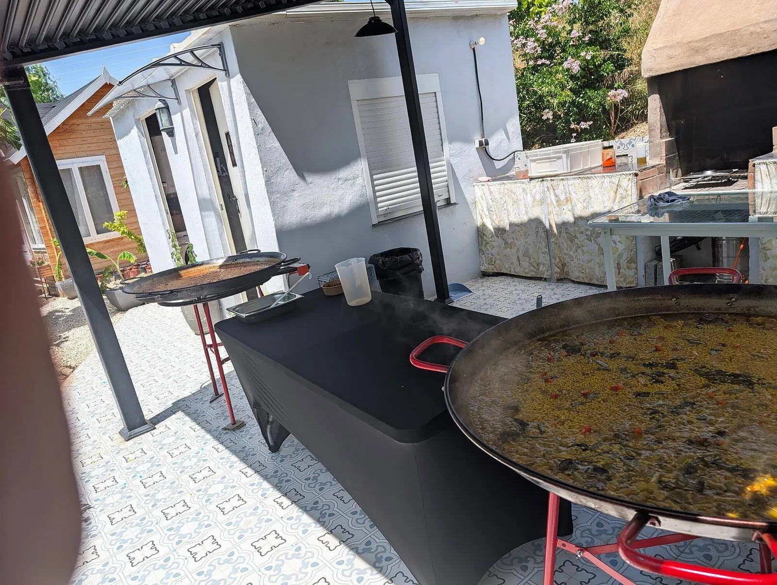 Paelleras y mesa de cocina preparadas en un espacio exterior
