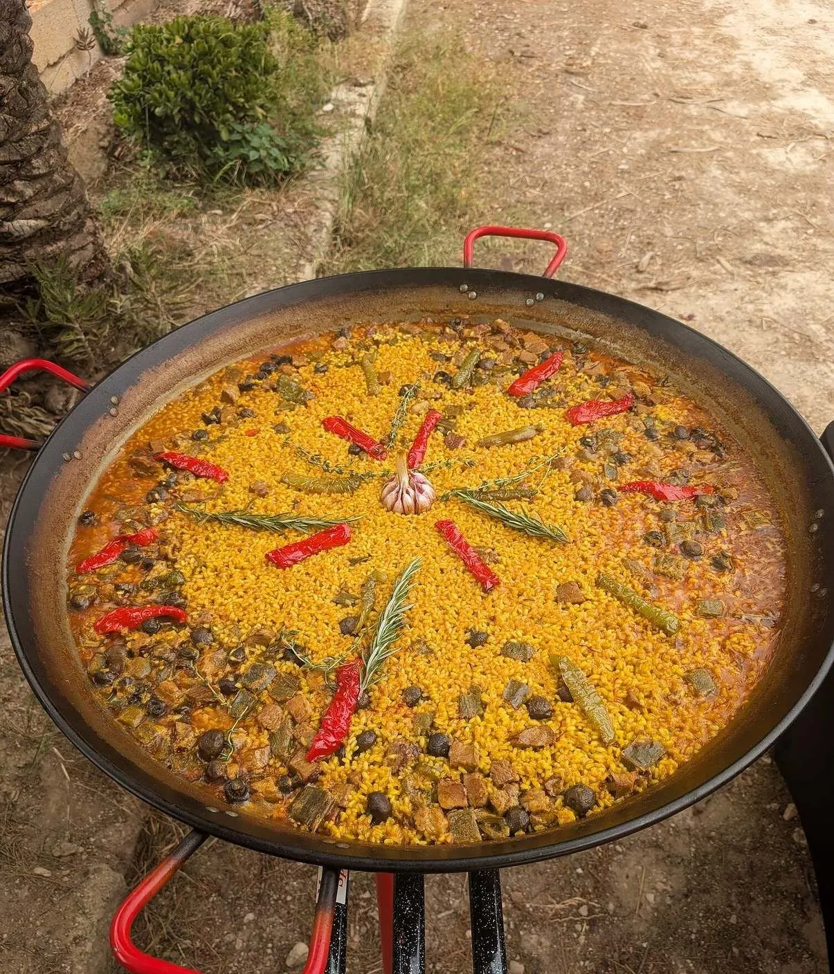 Arroz con verduras y tiras de pimiento rojo en una paellera